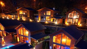 A residential area with multiple wooden houses, a swimming pool, and outdoor lighting. - Woodlodge Country Sapanca (Sapanca)