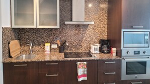 Uma cozinha moderna com bancadas de granito, eletrodomésticos de aço inoxidável e armários de madeira.
