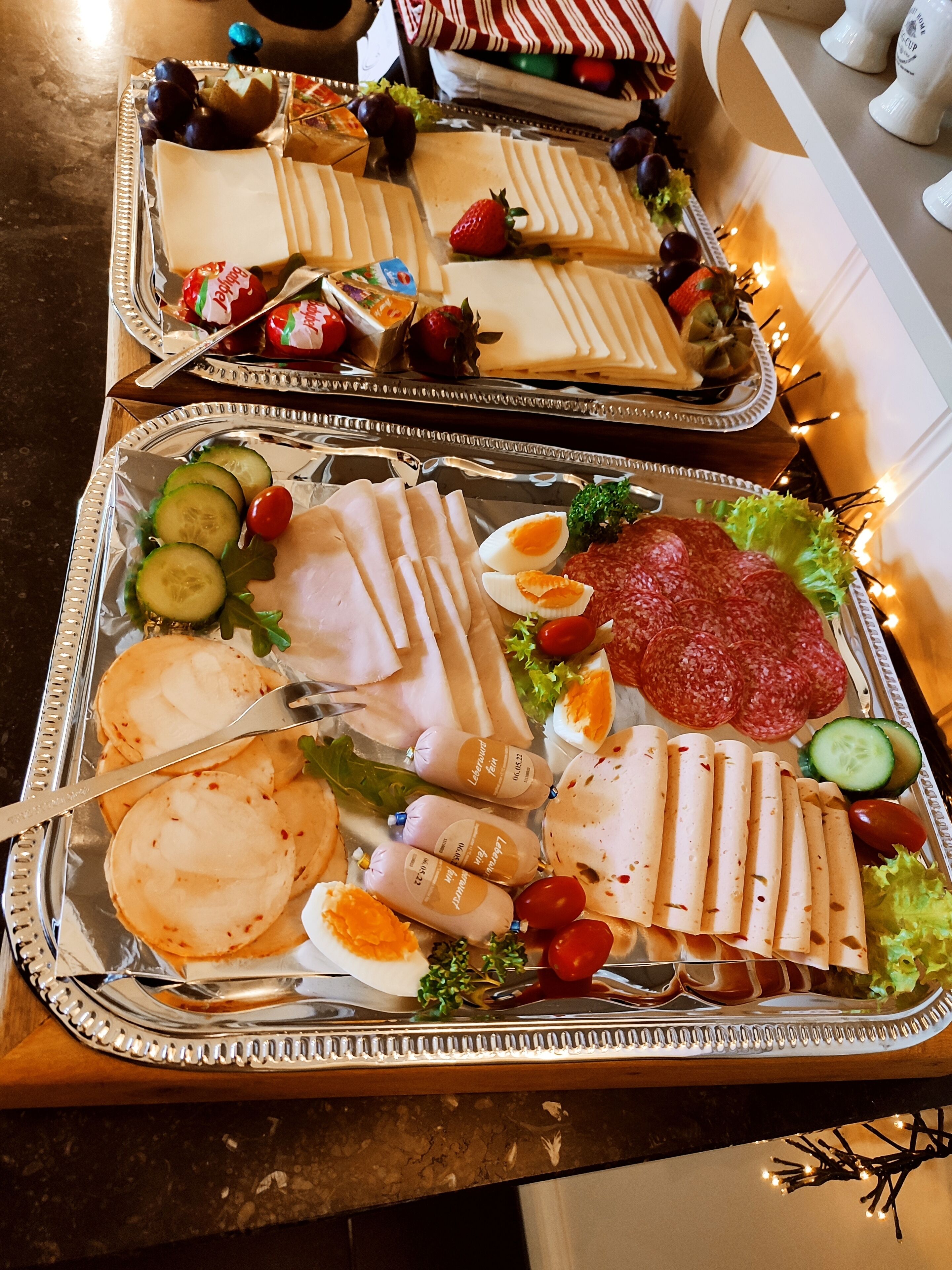 Une table de buffet proposant divers aliments, notamment des viandes et des fromages en tranches, ainsi que des légumes.