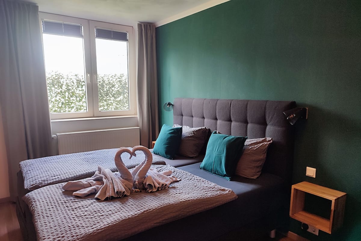 A bedroom with a bed, a window, and a wall unit.