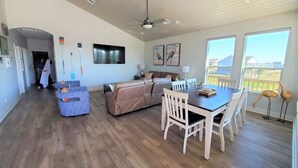 Un'ampia zona giorno con tavolo e sedie, un divano e una ventola a soffitto.