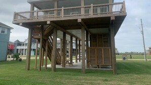 Una struttura in legno con un balcone, una scala e una zona relax coperta.