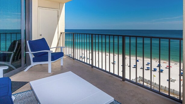 Ein Balkon mit Blick auf Strand und Meer.