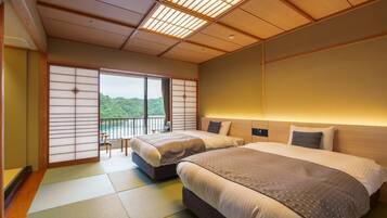 A hotel room with two beds, tatami flooring, a sliding shoji screen, and a view of greenery.