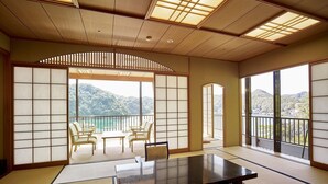 Una habitación japonesa tradicional con suelo de tatami, una mesa baja y puertas correderas.