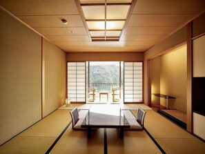Une pièce de style japonais traditionnel, avec un sol recouvert de tatamis, une table basse et des portes coulissantes.