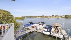 A marina with several boats docked, a sign indicating boat rental, and a view of the surrounding landscape. - Caddy's #1 – Waterfront Balcony, Walk to Beach, Pet-Friendly & Next to Dining (Indian Shores)