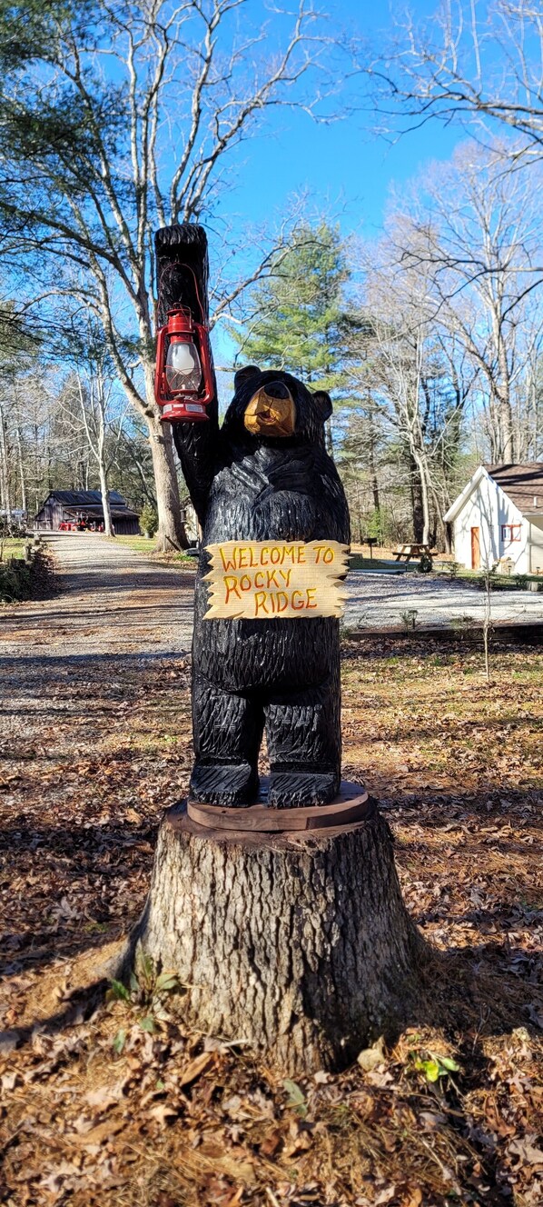 Una estatua de madera de un oso con un letrero que dice 'Welcome to Rocky Ridge'.