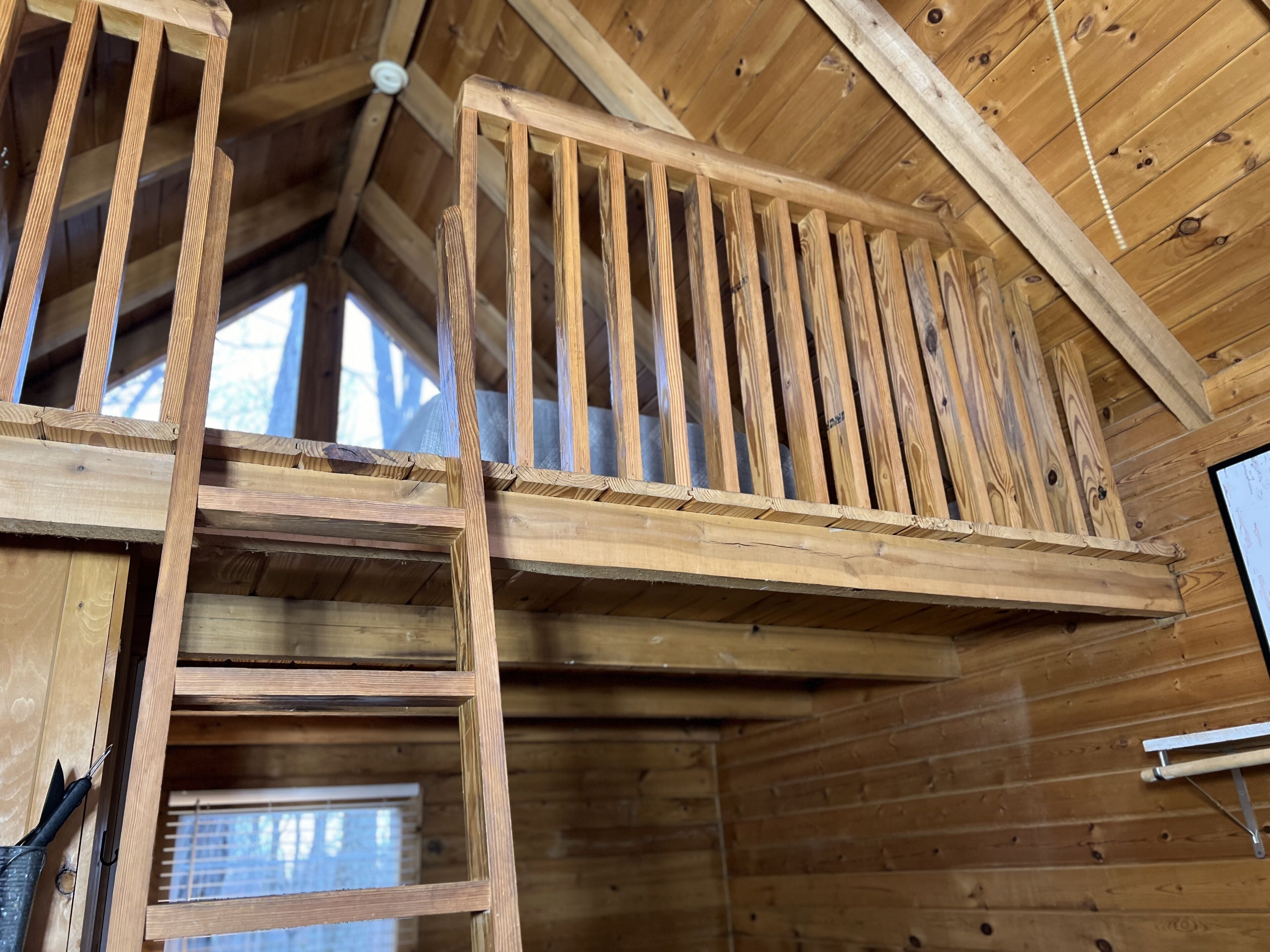 A wooden staircase with a railing, leading to an upper level.