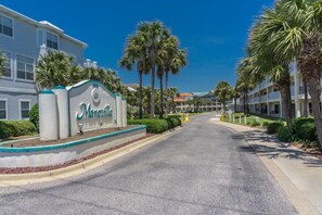 A street view of Marietta with a sign, palm trees, and a building with balconies.