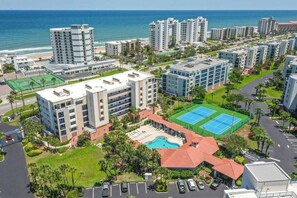 A high-rise hotel complex with multiple buildings, a swimming pool, and a tennis court.