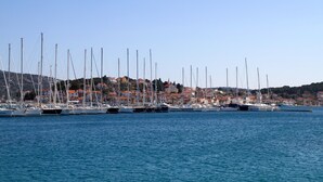 A marina with multiple sailboats docked, a coastal town in the background, and clear skies. - Spacious apartment w. balcony, big garden & grill (Podglavica)