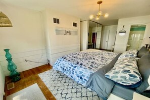 Cozy retreat with a large bed, wooden floor, and a window.