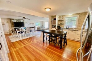 Enjoy meals in the central dining area with a table for four and a fully equipped kitchen nearby.
