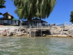 Waterfront property with a cabin and a larger building, featuring a dock and scenic views.