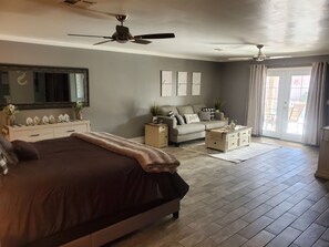 Cozy retreat with a large bed, dresser, and window with curtains.