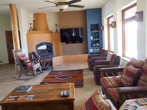 Cozy living room with a fireplace, comfortable seating, and a television.