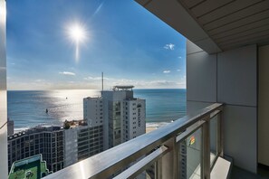 Un balcón con vista al océano y un edificio con el rótulo 'SEA CLOUD'.