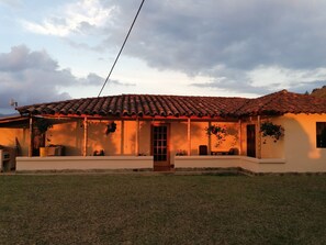 Guests can enjoy an entrance and a covered porch area with a bench.
