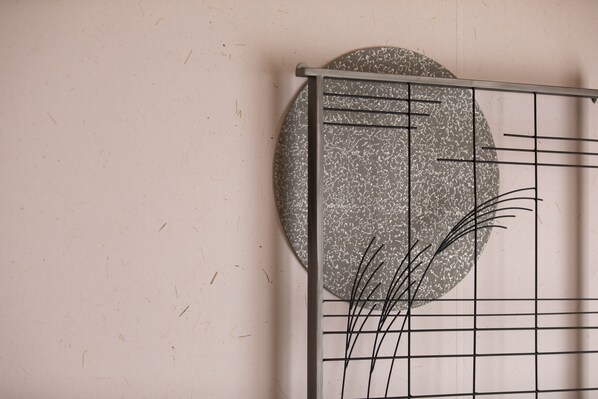 A wall with a circular textured pattern and a metal grid structure.