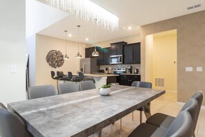 A modern kitchen with dark cabinets, a stainless steel refrigerator, and a microwave. - Beautiful 6 Bedroom Home w/ Private Pool and Spa at Windsor Island (Davenport)