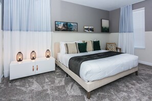 Une chambre à coucher avec un lit, une table de chevet et des étagères murales décorées de tableaux.