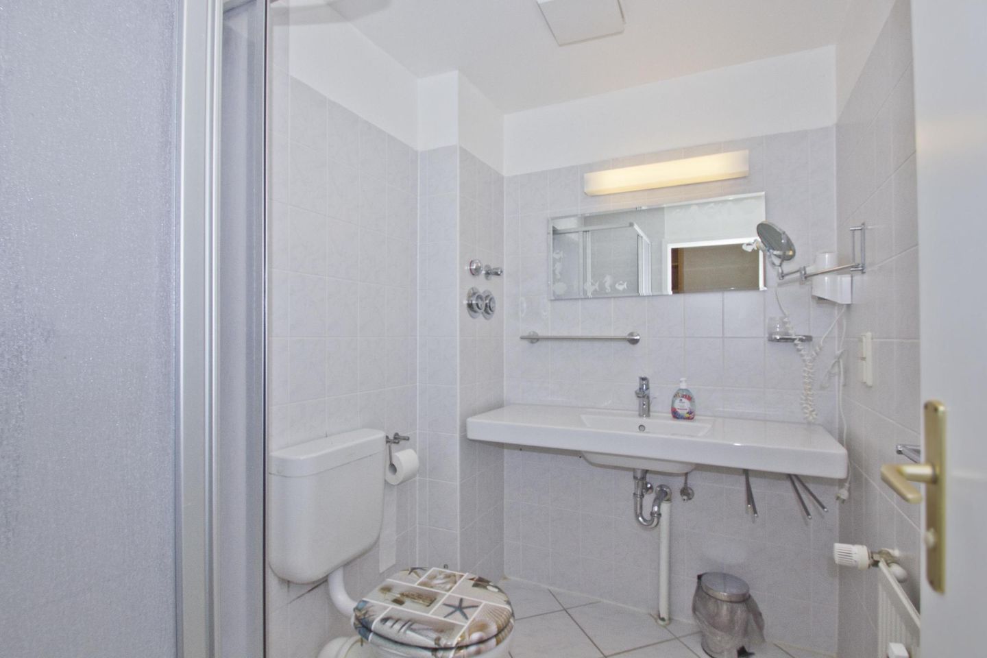 Ein kleines Badezimmer mit Toilette, Waschbecken und Dusche.