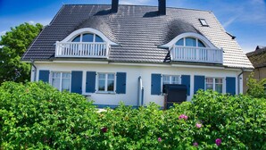 A two-story house with a gabled roof, white exterior walls, and blue shutters. - Vacation home Milan - waterfront vacation home with fireplace, sea view and garden - (Gager)