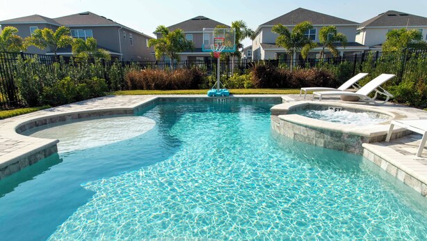 A swimming pool with a hot tub, lounge chairs, and a basketball hoop. - Family Escape With Private Pool & Themed Rooms (Kissimmee)