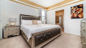 A bedroom with a large bed, a nightstand, a dresser, and a painting on the wall. - Beautiful 6 Bedroom Home With Private Pool and Game Room Ww1508 (Kissimmee)
