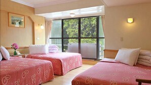 Een hotelkamer met twee bedden, een groot raam en een schilderij aan de muur.