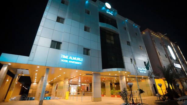 A modern hotel with a prominent entrance and illuminated signage.