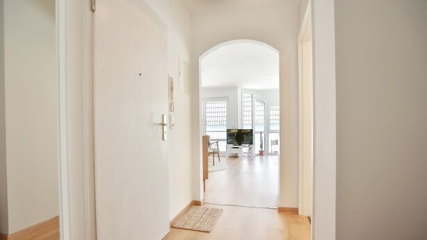 A hallway leading to a living area with a TV, wooden flooring, and white walls. - Gorch-Fock-Str 16 Apartment 6 - Gorch-Fock-Str 16 (Timmendorfer Strand)
