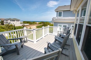 A wooden deck with outdoor furniture, a white railing, and a view of the ocean and beach. - Oceanside, 8 BRs, Private Pool, Theater Room, Rec Rm, Hot Tub, OL126, Knot Tide Up (Corolla)