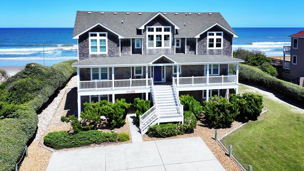 A two-story house with a front porch, a staircase, and a view of the ocean. - OCEANFRONT, 10 BRS, ELEV, Pool, Rec Rm, Theater Rm, OH1251, Beach Plaza (Corolla)