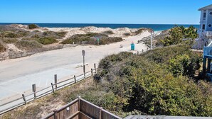 A beach view with a wooden boardwalk, a lifeguard tower, and a sandy beach area. - Semi-Oceanfront, Close to Beach Access, Private Pool, Hot Tub, 109, Happy Ours (Corolla)