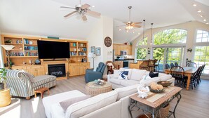 A spacious living area with a fireplace, a television, and a dining area with a view of the outdoors. - Soundfront, ELEV, Private Pool, Pool Table, Water Views, VOH1, Soundly Sea-Cluded (Corolla)