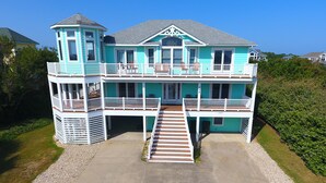 A two-story house with a balcony and a covered porch.