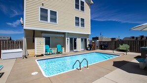 A two-story house with a backyard pool, outdoor seating, and a fenced area. - Semi-Oceanfront, Private Pool, Hot Tub, Game Room, KD1502, Tide Watcher (Kill Devil Hills)