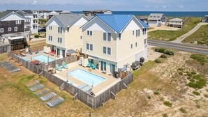 A two-story house with a large backyard, a swimming pool, and a view of the ocean. - Semi-Oceanfront, Private Pool, Hot Tub, Game Room, KD1502, Tide Watcher (Kill Devil Hills)