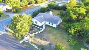A house with a curved driveway, surrounded by trees and a grassy yard. - Leander 3BR Retreat | Lake Travis Access (Leander)