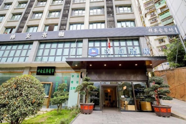 A hotel entrance with a sign for '汉庭酒店'.