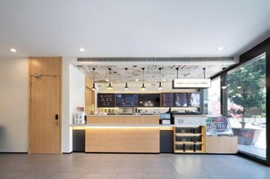 A modern coffee shop interior with a wooden counter, menu boards, and pendant lighting.