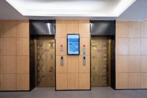 An elevator with a digital display and emergency contact buttons.