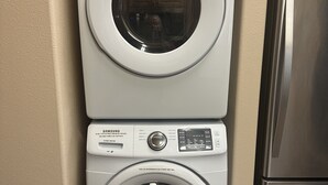 A stacked washer and dryer unit in a corner with a stainless steel refrigerator adjacent to it. - Heartland studio in North Pole, Alaska - plus extras  (North Pole)