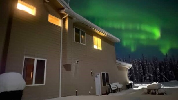 A house with a snow-covered roof and a visible door. - Heartland studio in North Pole, Alaska - plus extras  (North Pole)