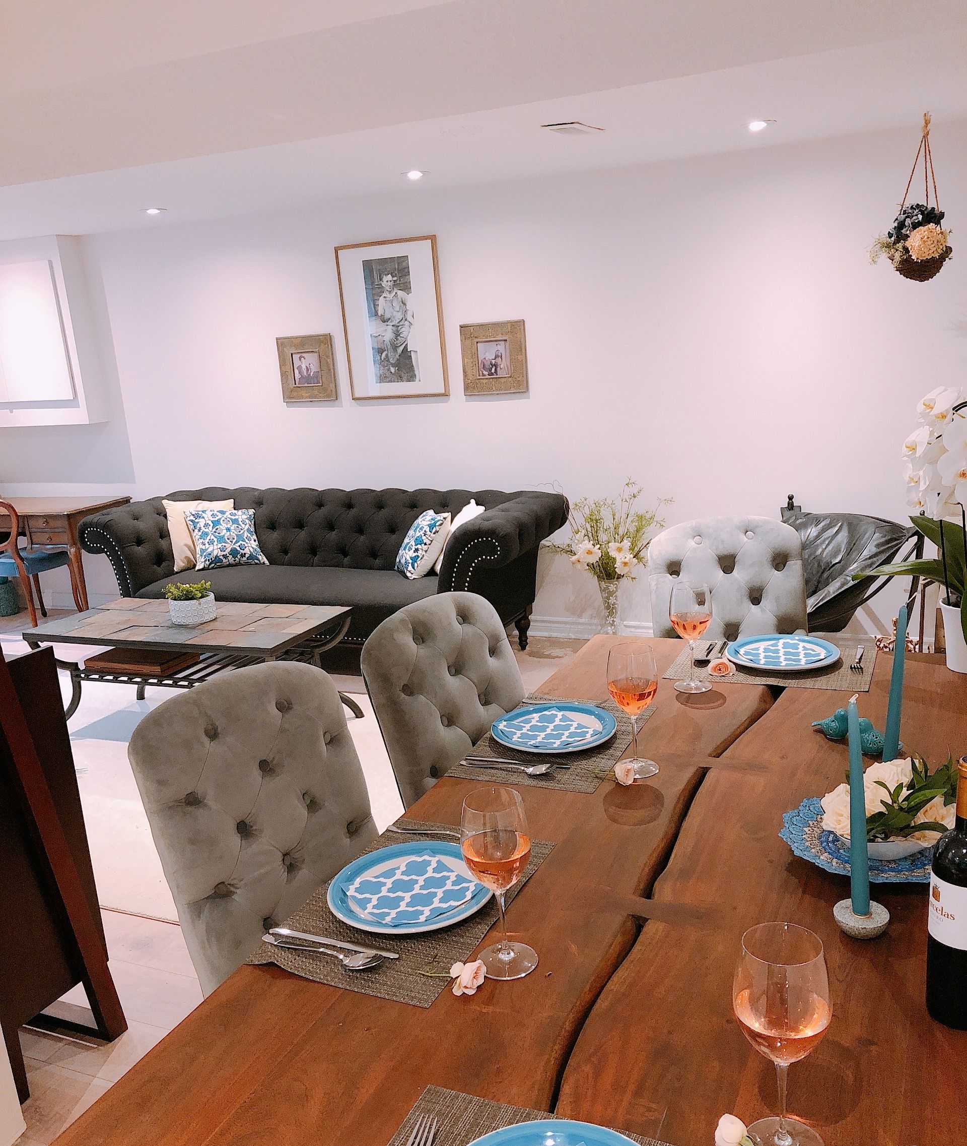 Un coin repas avec une table en bois dressée pour deux personnes, agrémentée d’assiettes à motifs bleus et de verres à vin.