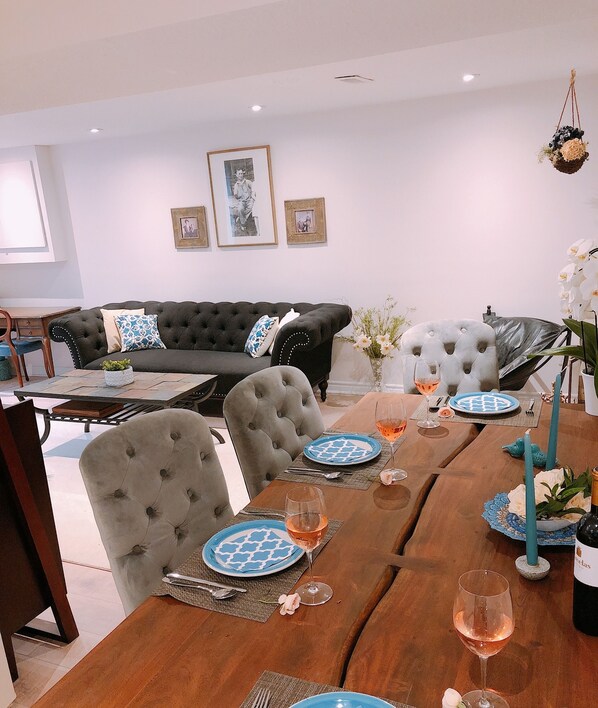 A dining area with a wooden table set for two, featuring blue patterned plates and wine glasses.