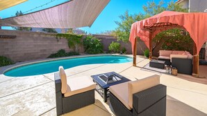 A backyard with a swimming pool, outdoor furniture, and a pergola. - Luxe 3 Bedroom Home with optional Heated Pool 🌊 6Mi to LV Strip!💫✨ (Las Vegas)