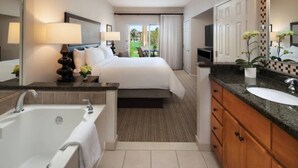 A hotel room with a large bed, a separate bathroom with a bathtub, a sink, and a mirror. - Marriott Shadow Ridge-The Villages Spacious 2-BR Full Resort Access (Palm Desert)
